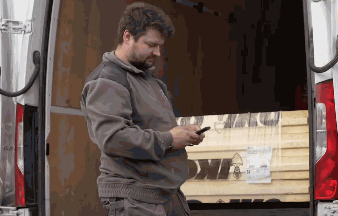 Site worker logging his hours on a smartphone